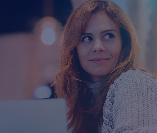 Person looking over shoulder slightly smiling 