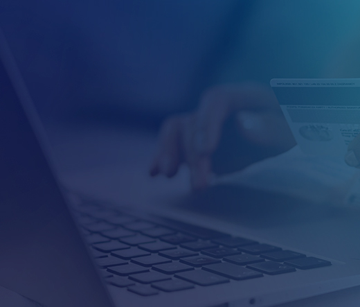 Hands shown at laptop with person holding credit card