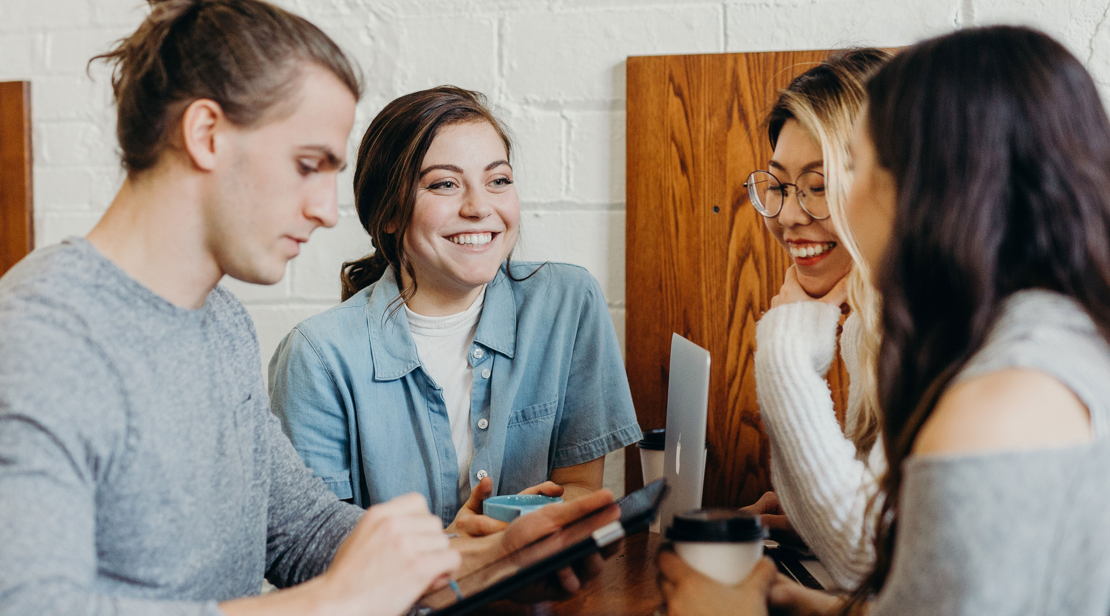 Group of people collaborating around a laptop