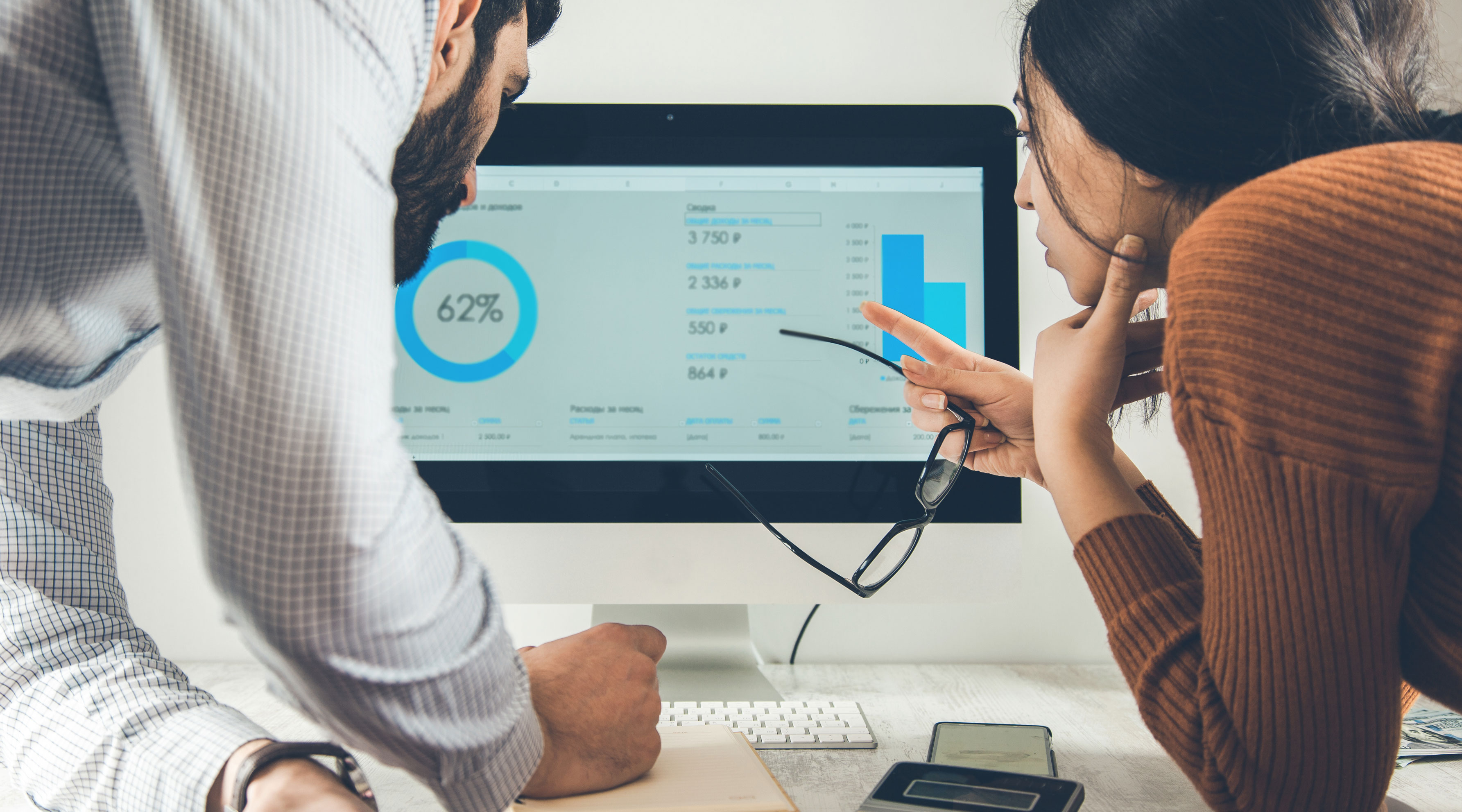 Man and woman looking at analytics data on computer screen