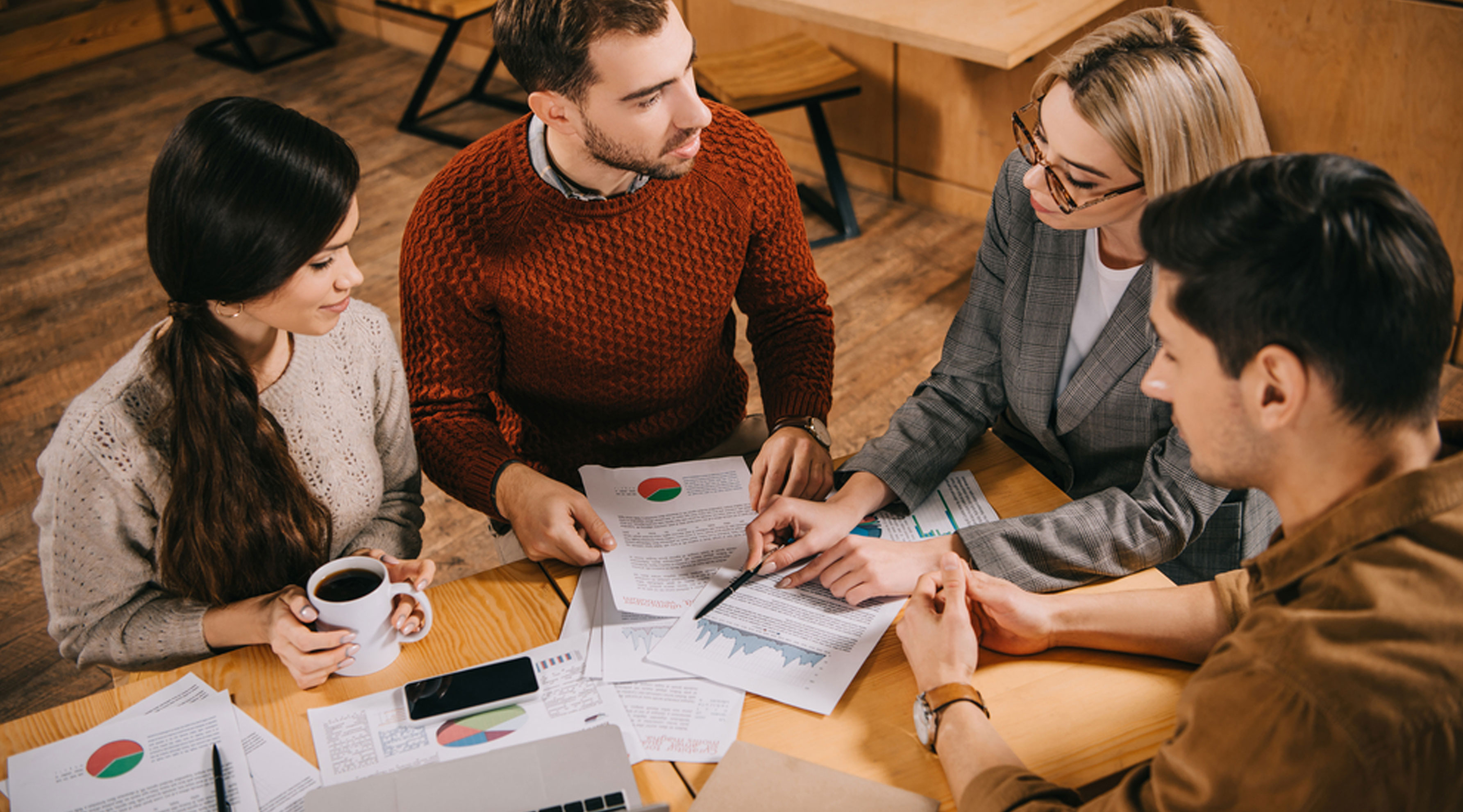 Group of four people around a table having a discussion